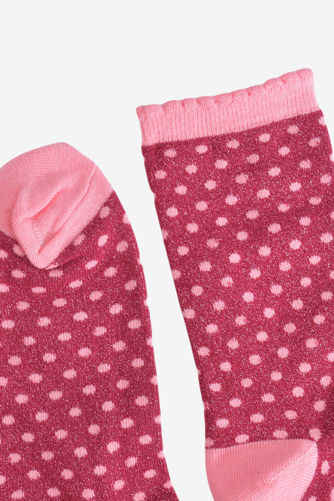 showing the cuff and the toe of the polka dot socks, both are light pink like the polka dots. the cuff has a scalloped edge