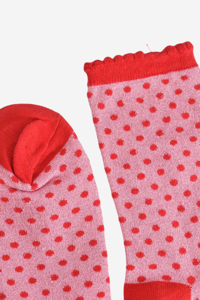 close up of the toe and cuff, the toe is red like the polka dot pattern, the cuff is also red and has a scalloped edge