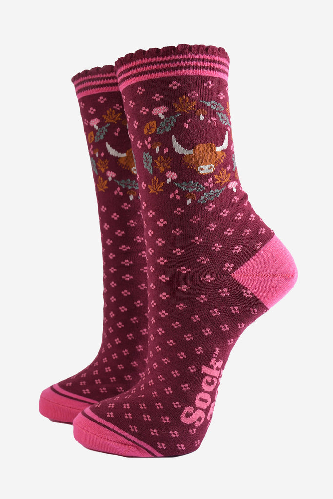 burgundy ankle socks with scalloped cuffs featuring a highland cow and a wreath featuring autumn leaves and woodland toadstools