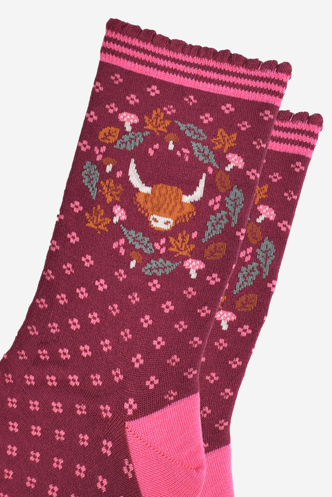 close up of the highland cow and wreath design which shows the head of a highland cow surrounded by autumn leaves and pink toadstools