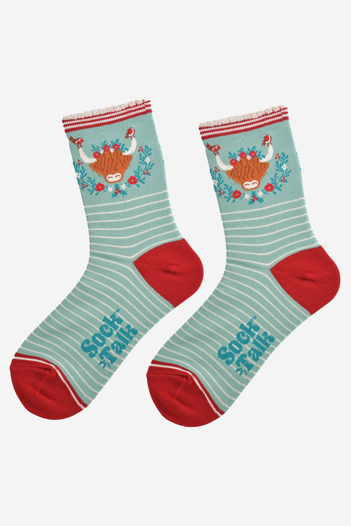 showing the socks laying flat, highlighting the white pinstripe pattern and large highland cow and wreath design on the ankle of the socks