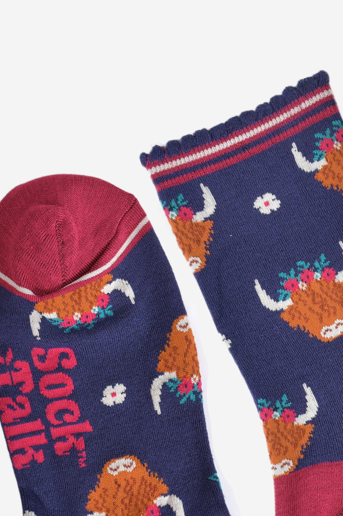 close up of the toe and cuff of the bamboo socks, the toe is berry pink with a white border stripe, the cuff is scalloped and had berry pink, white and navy blue stripes