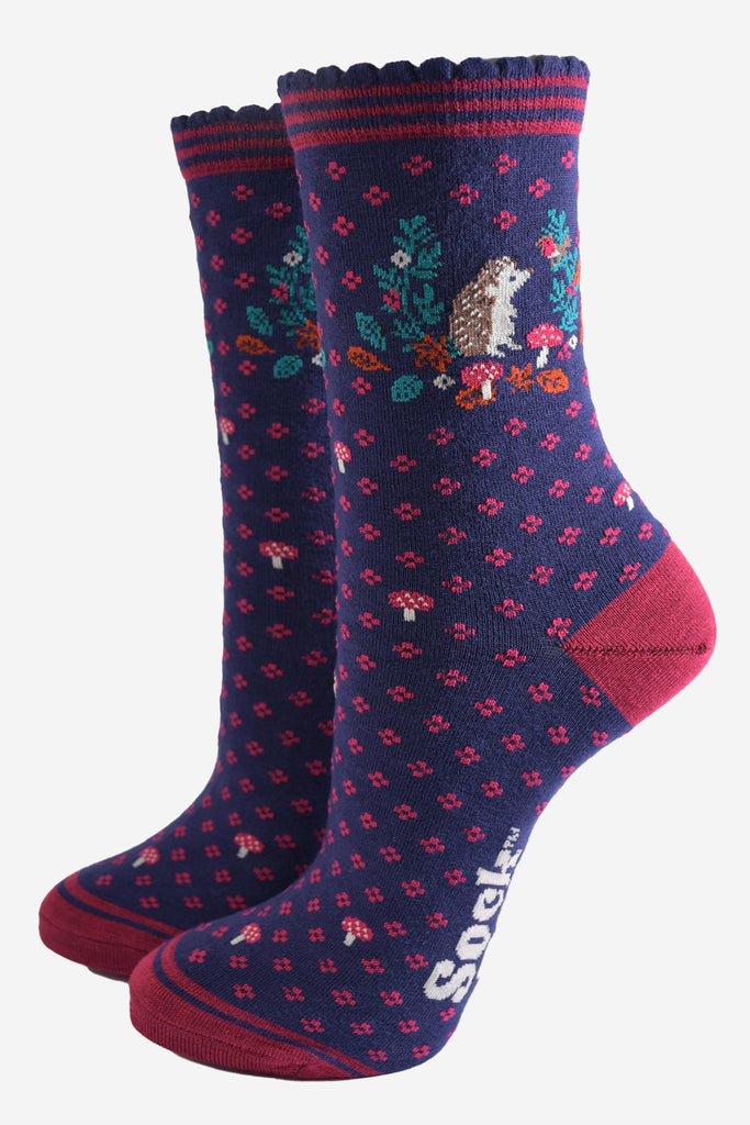 navy blue and pink ankle socks with a pattern of toadstools, a hedgehog and autumn leaves