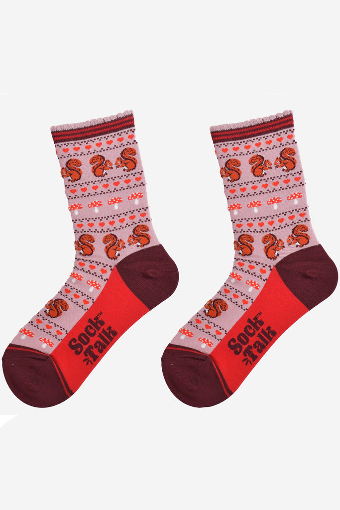 squirrel fair isle pattern socks laying flat, showing the all over pattern featuring red squirrels, toad stools and red love hearts