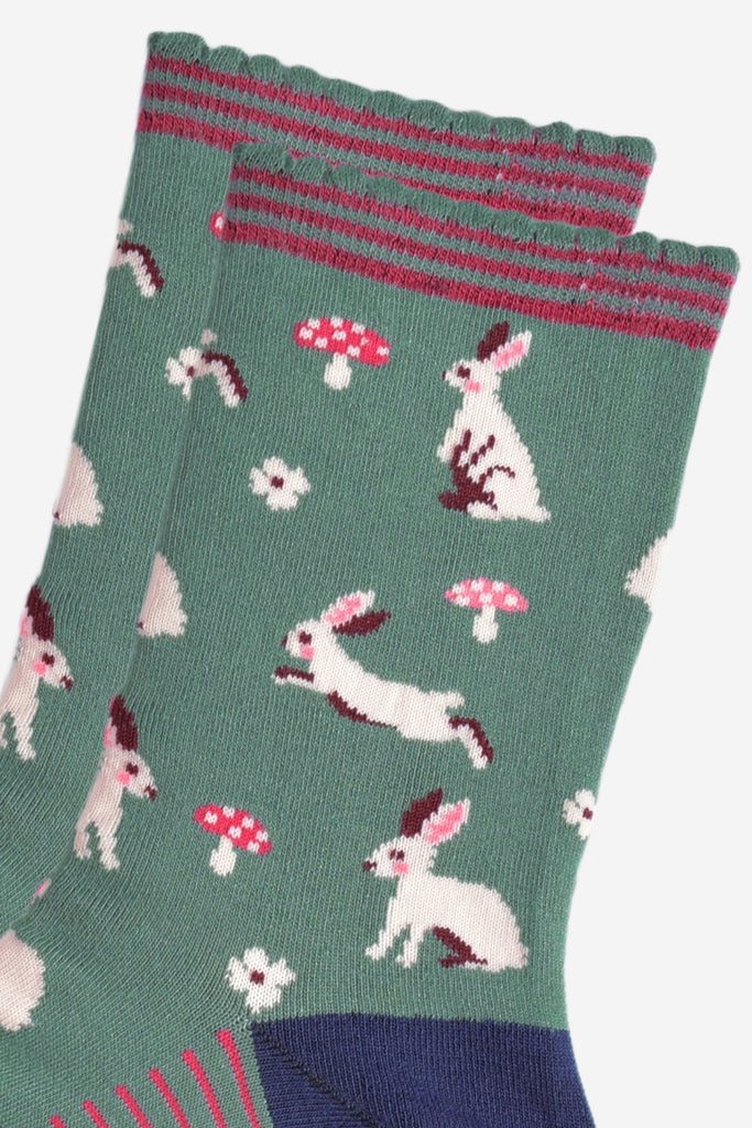 close up of the white rabbit design, the rabbits are sitting, hopping and standing, they have pink rosy cheeks and pink inner ears. there are pink and white toadstools and white flowers scattered around the design.