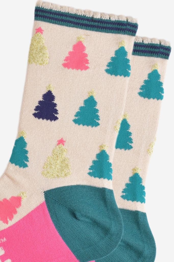 close up of the colourful christmas tree pattern, there are gold, pink, green and blue trees each with stars on the top