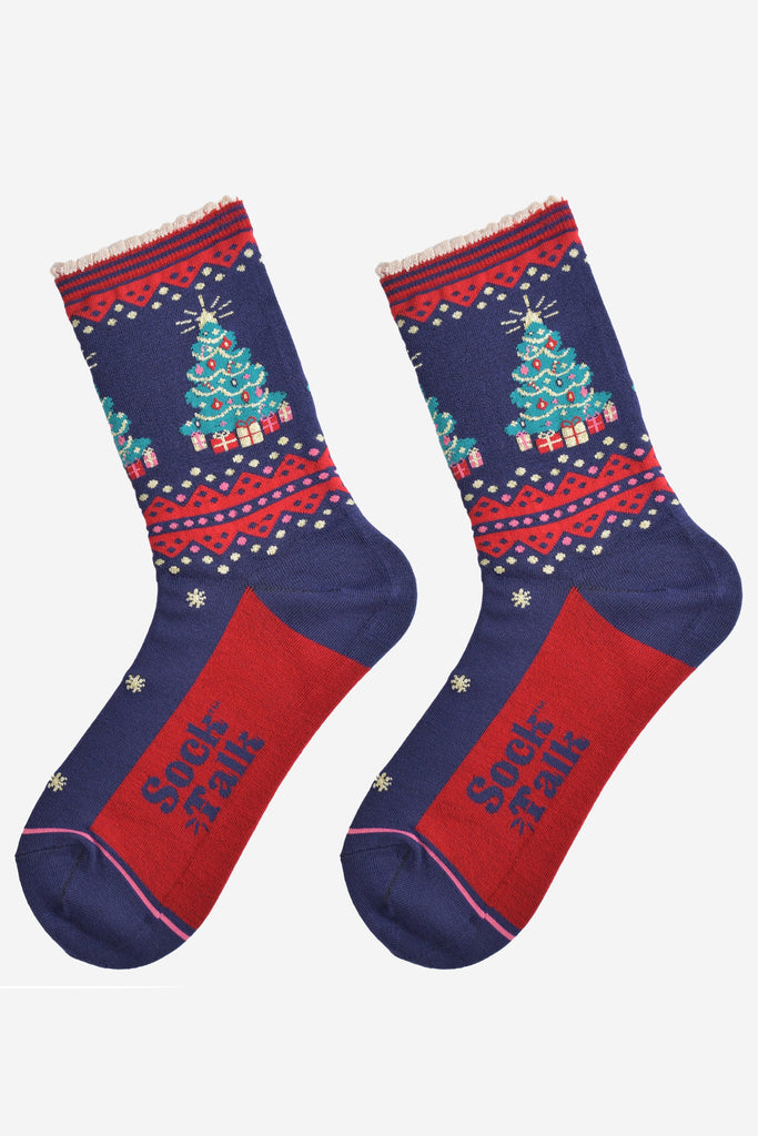 showing the christmas tree socks laying flat, they have a red sole, gold stars and a classic green christmas tree surronded by gifts on the ankle of the socks