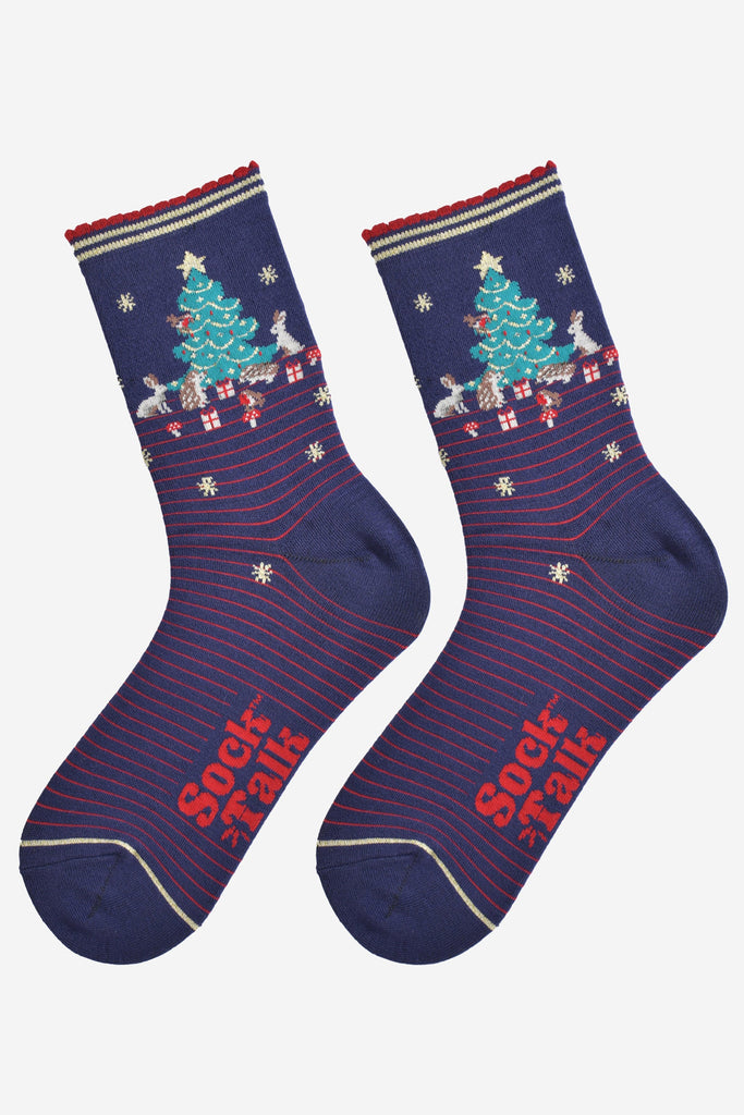 showing the woodland animal christmas socks laying flat, showing a red pinstripe pattern, gold stars and the christmas tree scene on the ankle