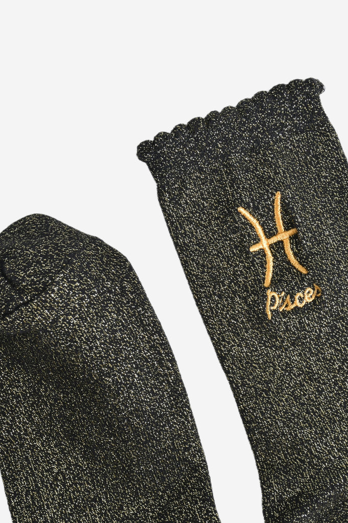 showing the toe and cuff of the socks, they are the same black and gold sparkly colour as the body of the socks, the cuff is scalloped shaped like a slight frill