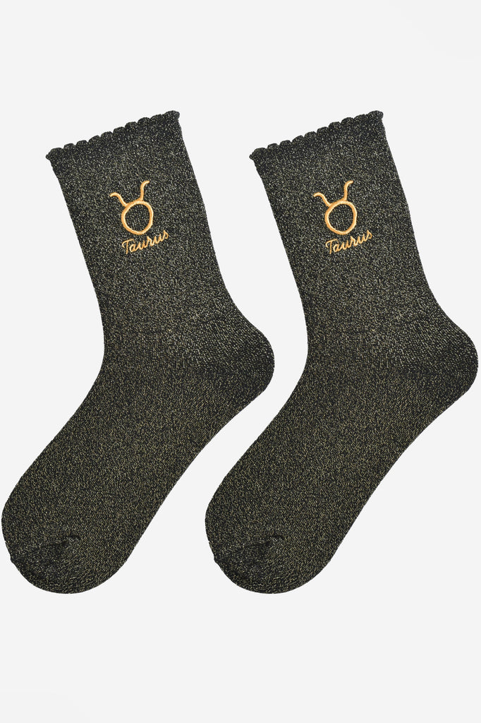 black and gold glitter embroidered taurus socks laying flat, showing the all over gold glitter sparkle