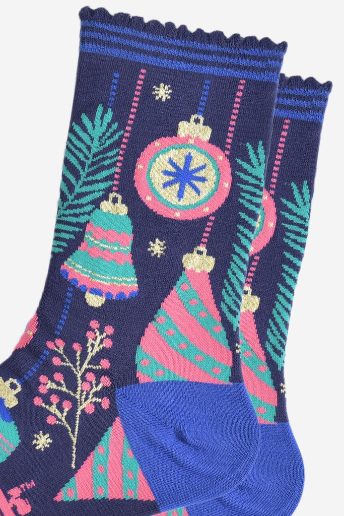 close up of the ornate xmas bauble pattern, there are round baubles with and bells, each are multi-coloured in pink, mint green. royal blue and gold.