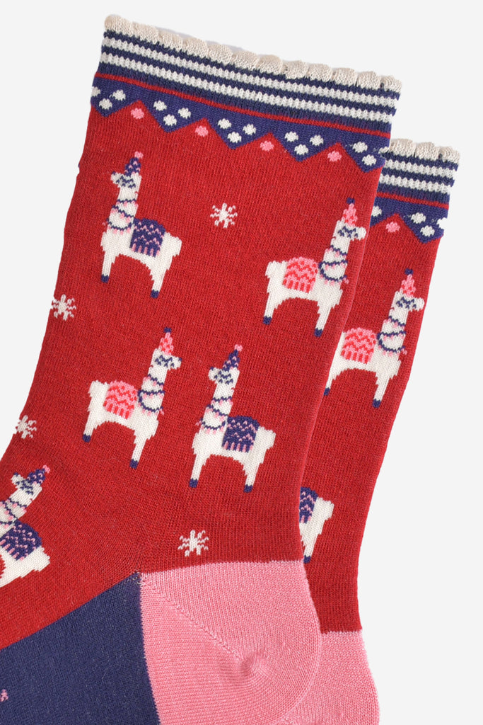 close up of the llama pattern, the llamas are wearing pink or purple coats and party hats, they also have party lights draped around their necks