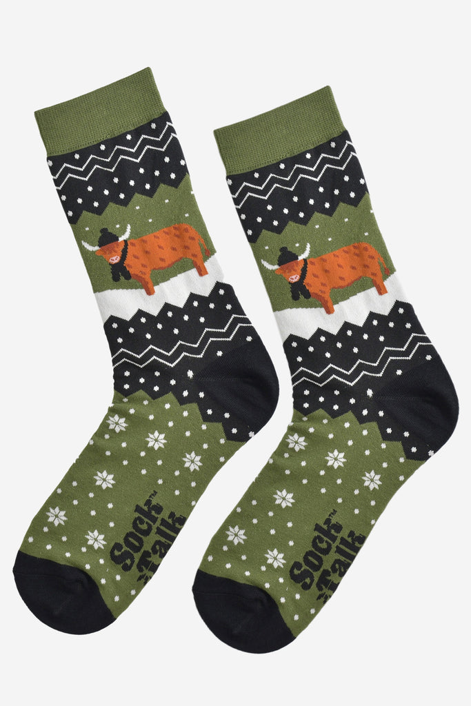 showing these green fair isle pattern highland cow socks laying flat, showing the overall festive winter pattern