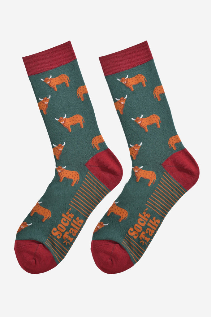 green and red highland cow bamboo socks laying flat, the highland cows are shown in profile and they are standing up