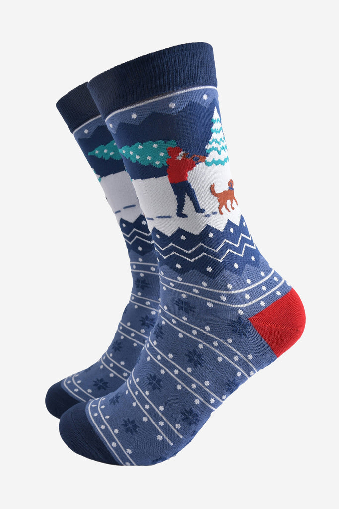 blue fair isle patterned socks featuring a dog walker carrying a xmas tree