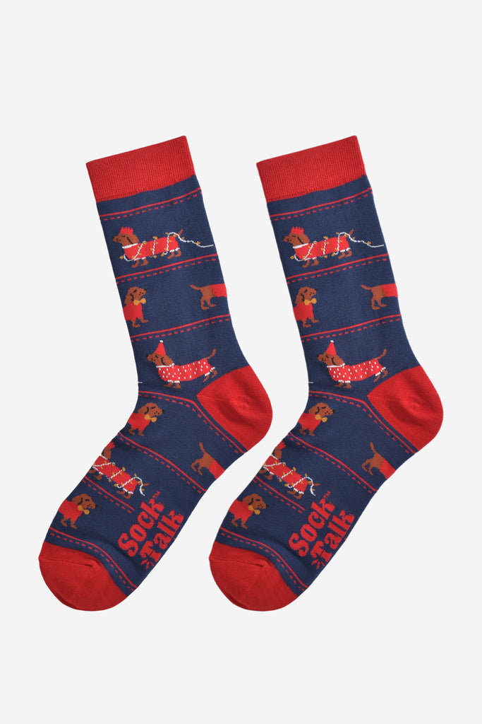 party sausage dog socks laying flat, showing the all over design with the dachshunds wearing red festive coats, party hats and being entangled in the party lights