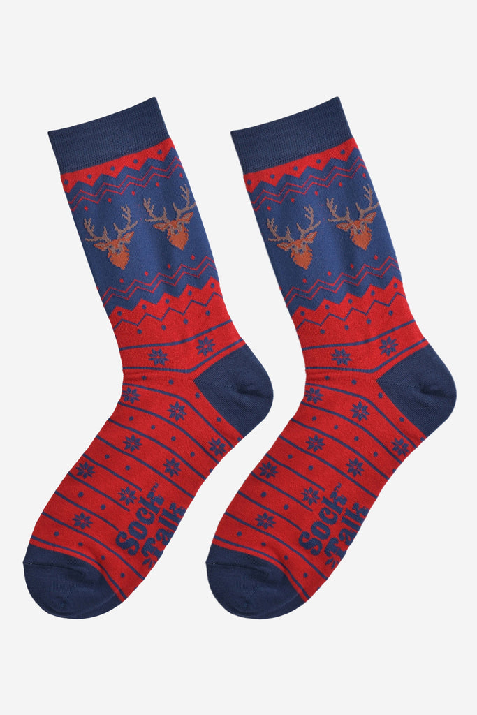 fair isle stag socks laying flat, showing the red and blue fair isle pattern and the two stags heads on each side of the ankles