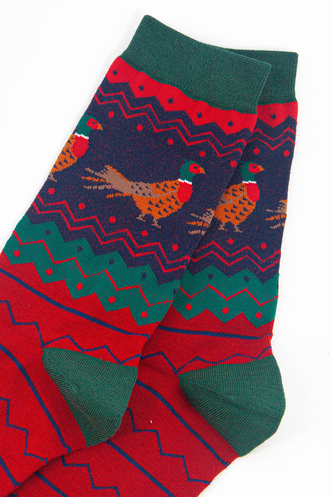 close up of the pheasant pattern on the ankle of the socks, the birds are brown and orange with red bellies and a green and red head. 