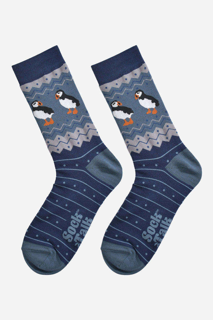 teal blue puffin fair isle socks laying flat, showing the full design of the sock, the puffins are clearly shown around the ankles