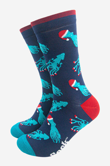 navy blue socks with an all over pattern of electric blue squid and octopus wearing santa hats