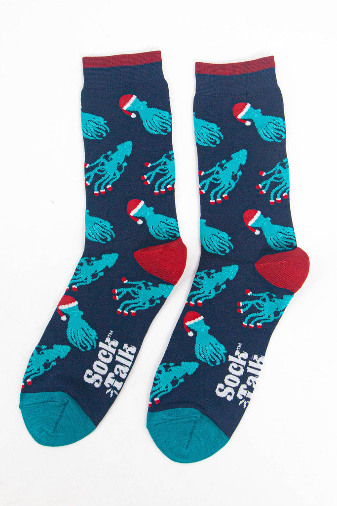 showing the christmas octopus and squid socks laying flat, there is an all over pattern of electric blue coloured squid and octopus wearing santa hats and santa slippers