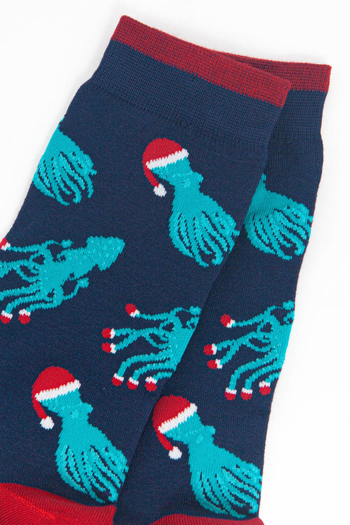 close up of the squid and octopus pattern, the octopus are wearing santa hats, the squid are wearing santa slippers on the ends of their tentacles