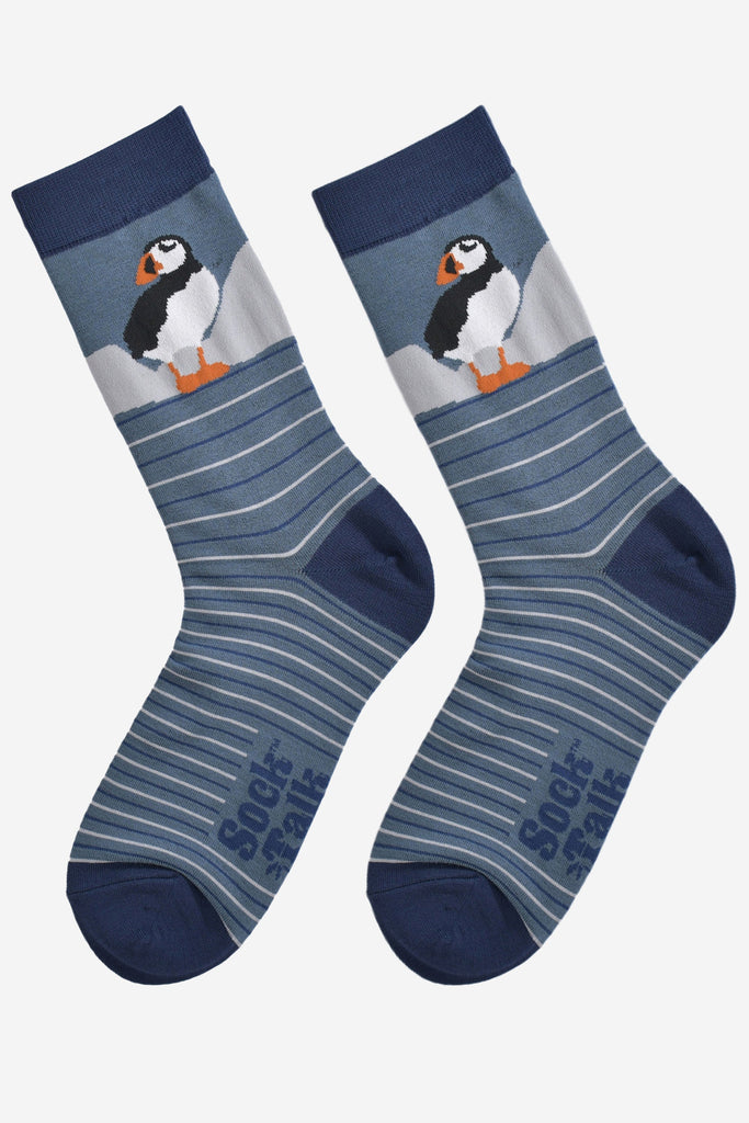 showing the striped puffin socks laying flat, showing the grey and blue stripes and the puffin design on the ankle.