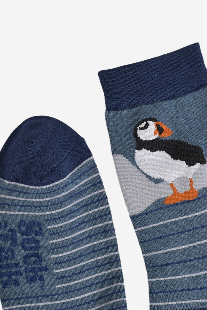 close up of the toe and cuff, both are navy blue in contrast to the teal blue background of the socks