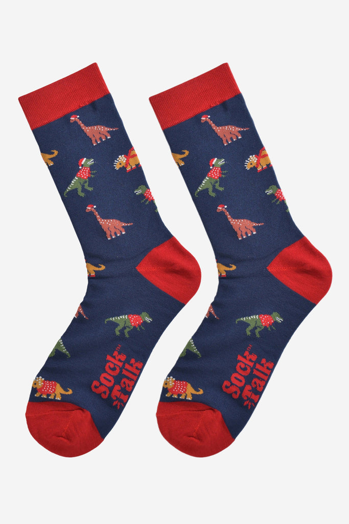 christmas dinosaur bamboo socks laying flat, showing the all over festive pattern of colourful dinosaurs wearing xmas hats and jumpers