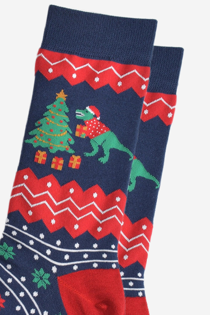 close up of the t-rex and xmas tree desing on the ankle, t-rex is putting gifts under the christmas tree and is holding one in his arms