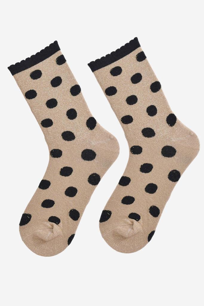 showing the gold and black polka dot socks laying flat, the silver glitter sparkle is visible and the black polka dot pattern is all over the design