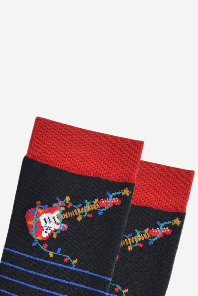 close up of the red electric guitar and multicoloured party lights on the ankle of the socks, the party lights are wrapped around the guitar