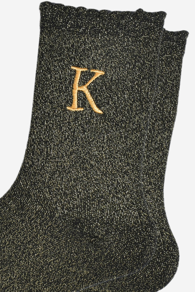 close up of the gold embroidered capital letter k on the ankle of the socks