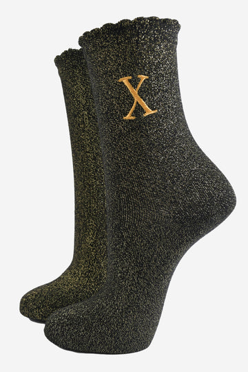 black ankle socks with a scalloped cuff, with an all over gold glitter sparkle and an embroidered gold letter x on the ankle