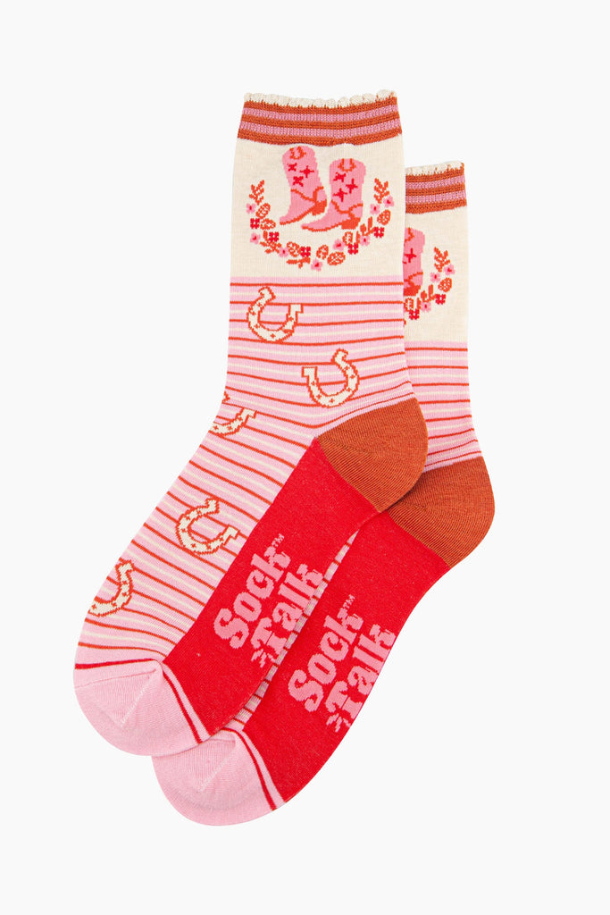 womens-bamboo-socks-cream-pink-cowboy-boot-stripe-laying-flat-the-body-is-striped-with-scattered-horseshoes-the-ankle-features-cowboy-boots-and-a-floral-wreath