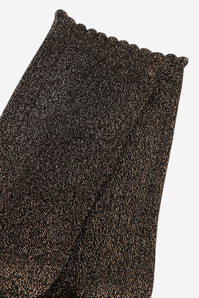 close up of the black and gold sparkly glitter socks, they have a scalloped cuff