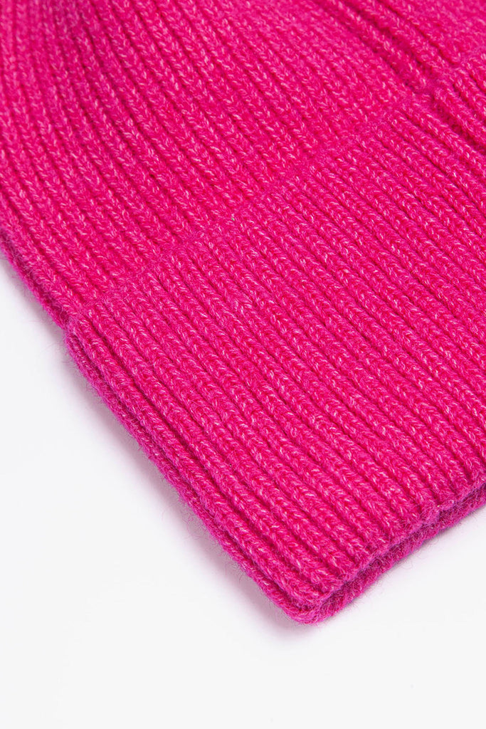 close up of the brim of the fuchsia pink knitted beanie hat, showing the ribbed design