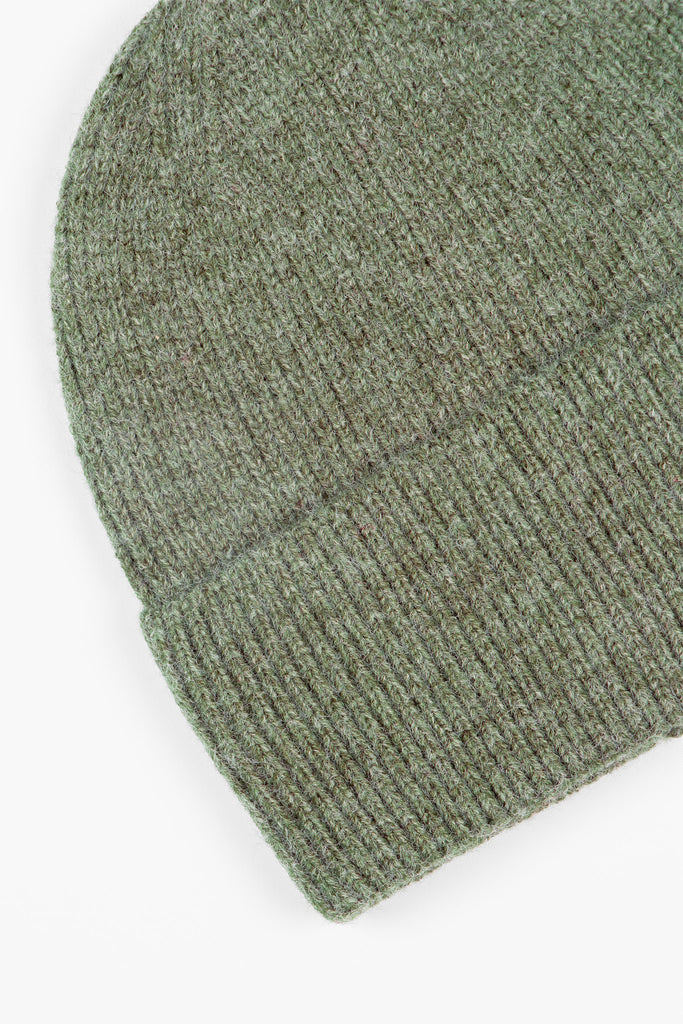 close up of the brim of the khaki green knitted beanie hat, showing the ribbed design