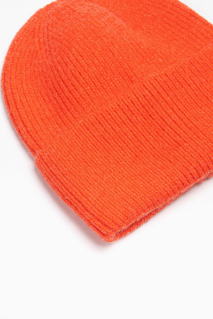 close up of the brim of the orange knitted beanie hat, showing the ribbed design