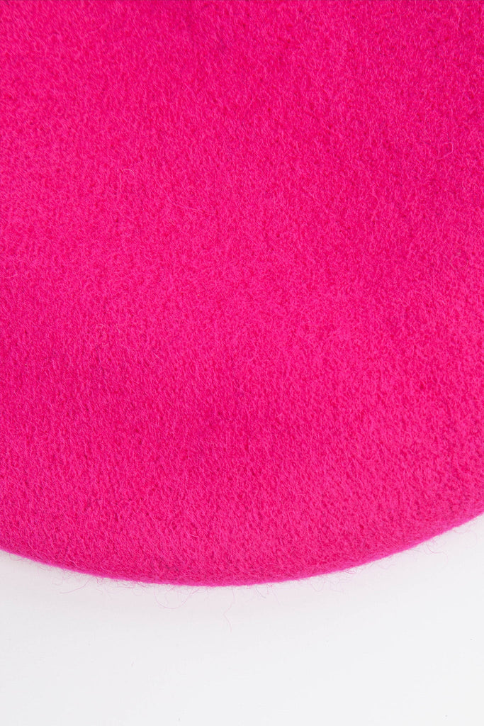 close up of the plain fuchsia pink beret, showing the textured wool blend fabric