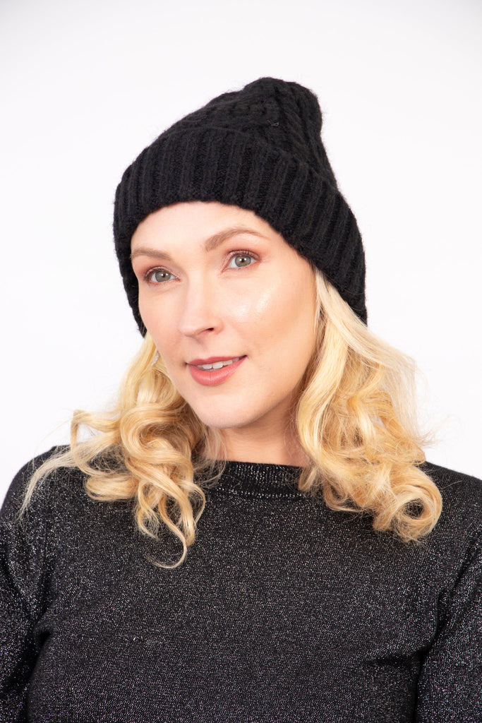 model wearing a black cable knit winter beanie hat