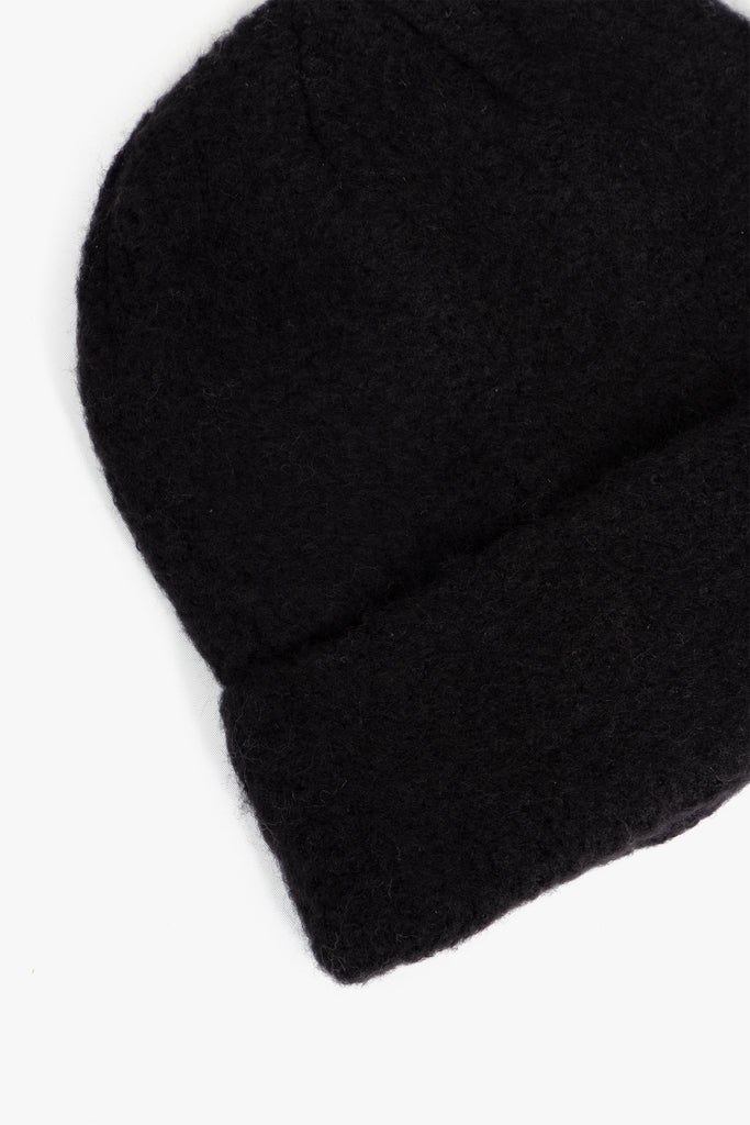 close up of the fluffy textured knitted fabric of the beanie hat.