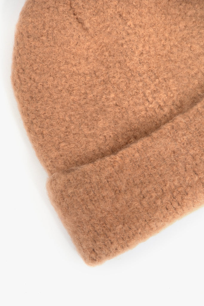 close up of the fluffy textured knitted fabric of the beanie hat.