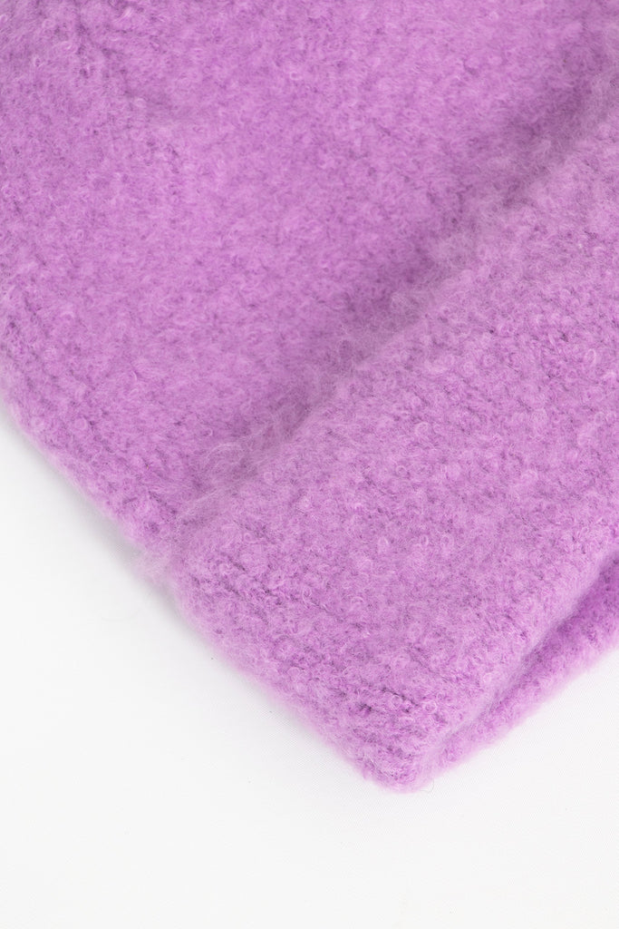 close up of the fluffy textured knitted fabric of the beanie hat.