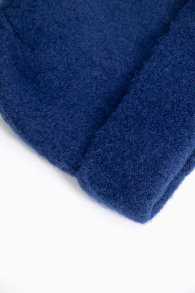 close up of the fluffy textured knitted fabric of the beanie hat.