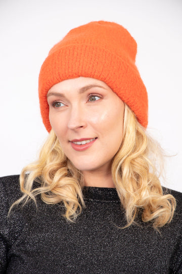 model wearing a textured knitted plain orange beanie hat