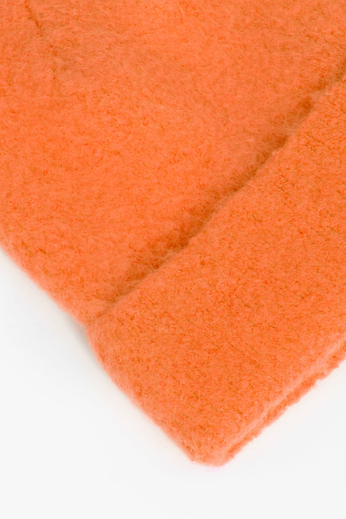 close up of the fluffy textured knitted fabric of the beanie hat.