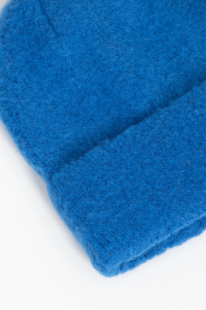 close up of the fluffy textured knitted fabric of the beanie hat.