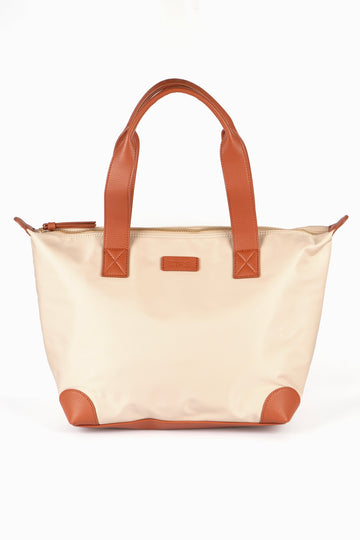 cream tote bag with brown tan accents and a brown carry handle, the bag has an external zip closure fastening on the top