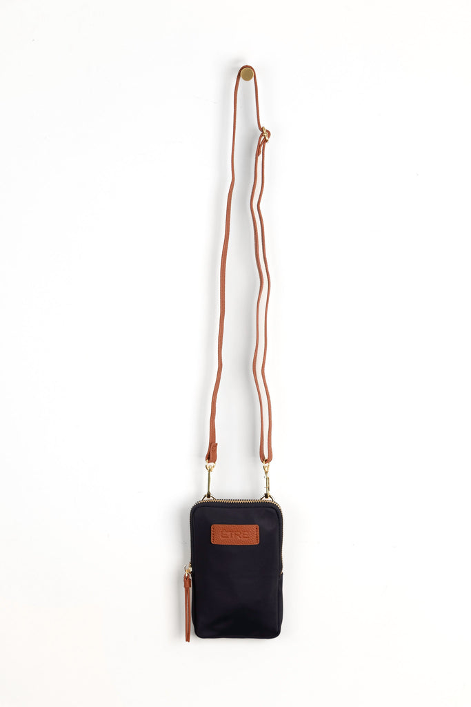 navy blue crossbody phone bag with tan accents and a tan removable adjustable crossbody strap